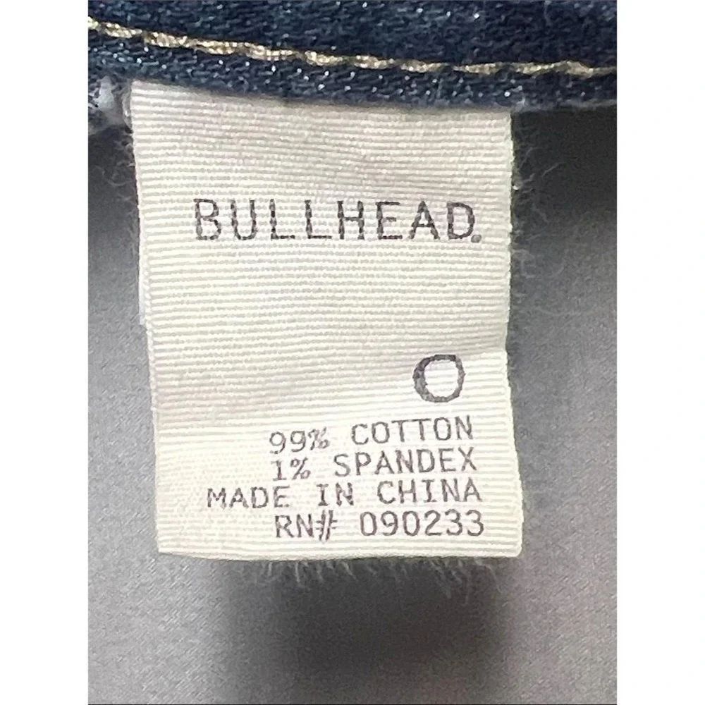 Bullhead denim shorts in a mid to dark blue wash. Rolled hem with cuffed